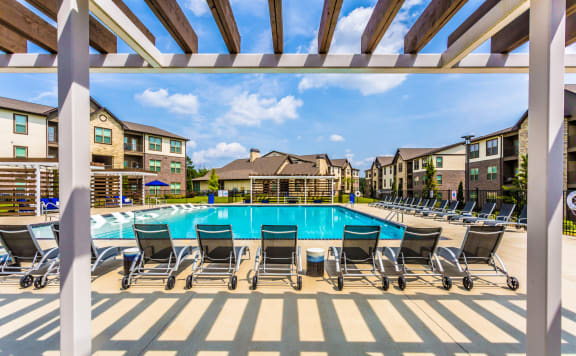 our apartments have a large swimming pool with chairs at The McKenzie Park Apartments, Arkansas, 72223