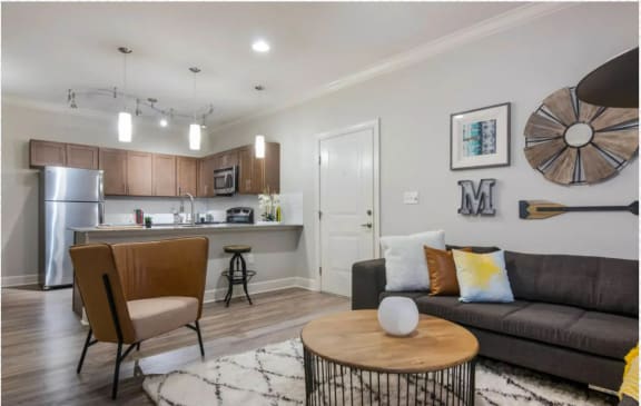 a living room and kitchen with a couch and a table at The McKenzie Park Apartments, Arkansas