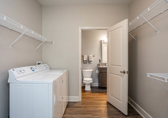a laundry room with a washer and dryer and a bathroom with a toilet at The McKenzie Park Apartments, Little Rock, AR 72223