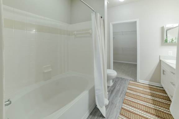 A white bathroom with a tub, toilet, and sink.