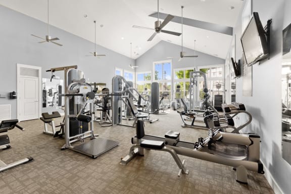 a gym with weights and cardio machines and a tv at The Ridge at Chenal Valley, Little Rock