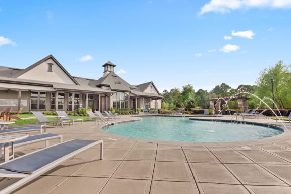 a resort style pool with lounge chairs and a building in the background at The Ridge at Chenal Valley, Little Rock, AR 72223