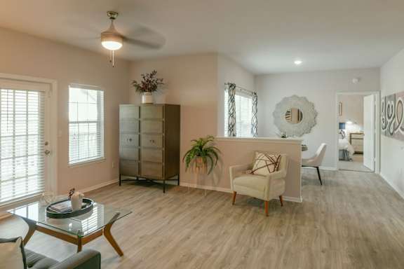 A living room with a glass table and a white chair.