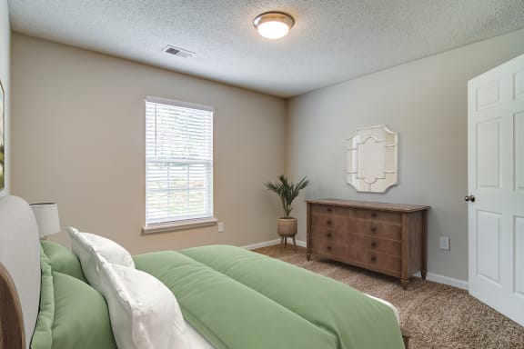 a bedroom with a bed and a dresser and a window  at Serene at Creekstone, Georgia, 30601
