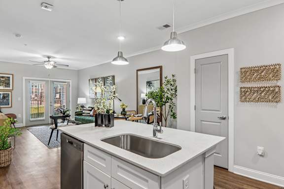 A modern kitchen with a large island and a stainless steel dishwasher.
