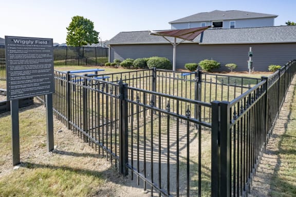 a fence with a sign in front of a yard with a pool