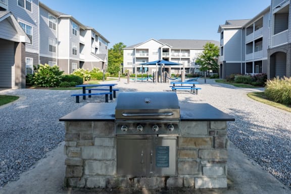 an outdoor kitchen with a grill in front of an apartment building at The Shallowford, Chattanooga, 37421