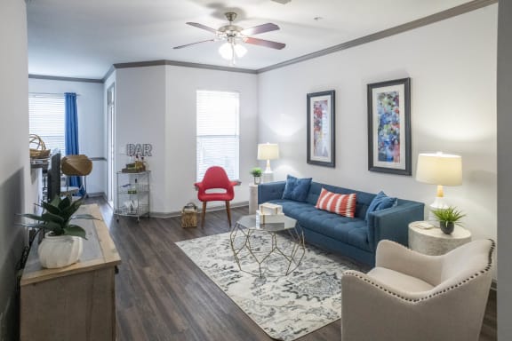 a living room with a blue couch and a ceiling fan