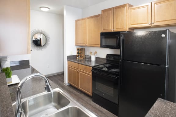 a kitchen with black appliances and wooden cabinets