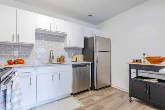 a kitchen with white cabinets and a stainless steel refrigerator at The Waters at Chenal, Little Rock, 72211