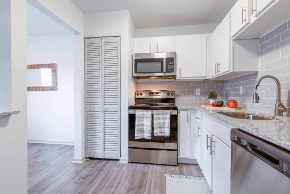 a kitchen with stainless steel appliances and white cabinets at The Waters at Chenal, Little Rock