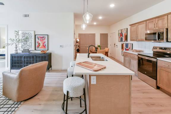 A kitchen with a white counter top and wooden cabinets.