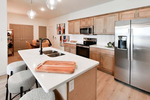 A kitchen with a white island and wooden cabinets.