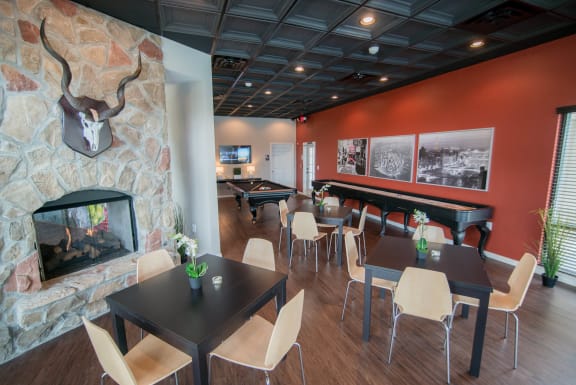 a dining room with tables and chairs and a fireplace at The Villa at River Pointe, Maumelle, 72213