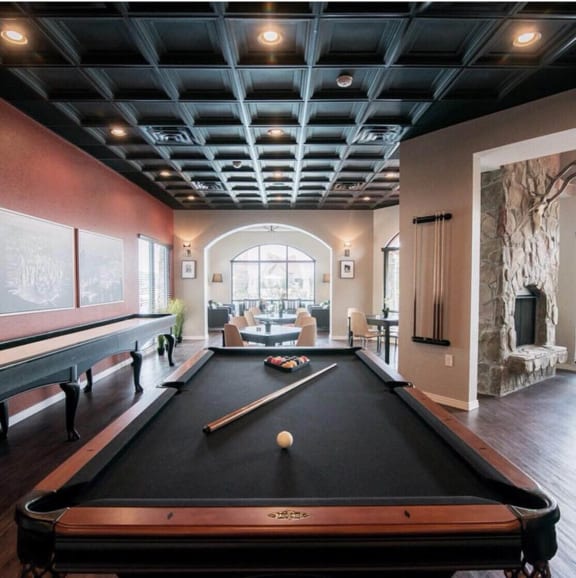 a pool table in a living room with a large window at The Villa at River Pointe, Maumelle, AR 72213