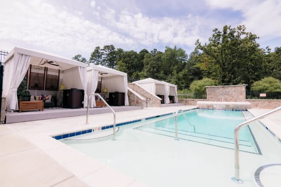 a swimming pool in front of a house with a pool at The Villa at River Pointe, Maumelle