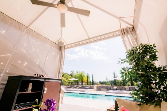 a living room with a pool and a ceiling fan at The Villa at River Pointe, Maumelle, 72213