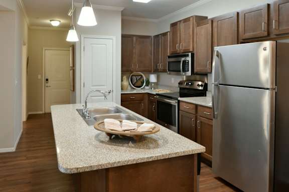 A kitchen with a granite countertop and stainless steel appliances. at Hall Creek Apartment Homes, Arlington, TN