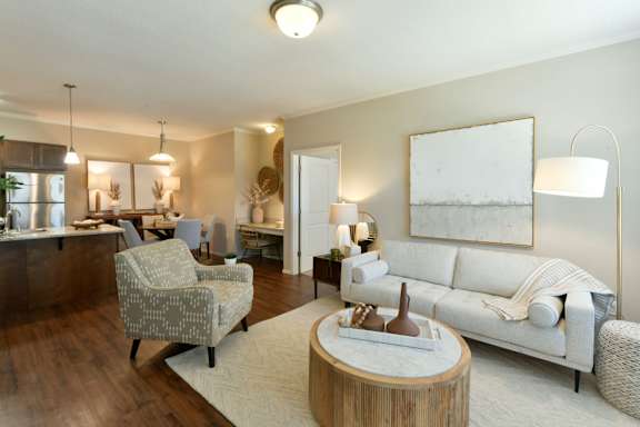A well-lit living room with a white sofa and a wooden coffee table. at Hall Creek Apartment Homes, Tennessee