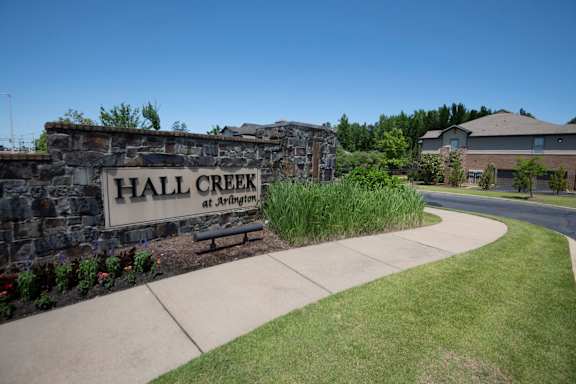A sign that says Hall Creek at Arlington is on a stone wall. at Hall Creek Apartment Homes, Arlington, TN