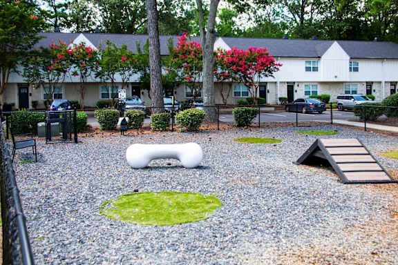 A playground with a white slide and a green lawn.