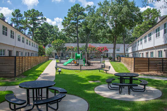 A playground area with a slide and picnic tables.