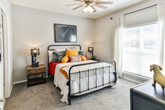 a bedroom with a bed and a ceiling fan