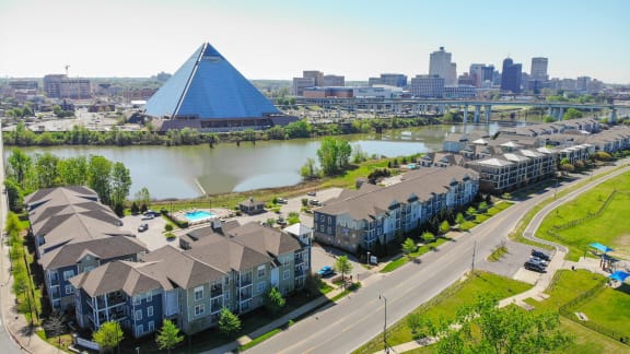 an aerial view of apartments in front of a river and a pyramid shaped building