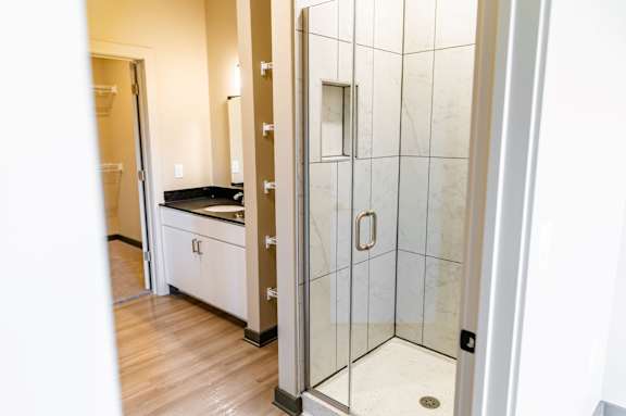 A bathroom with a walk-in shower and a vanity at Harbor Side at Conwood Flats Apartments in Uptown Memphis, TN