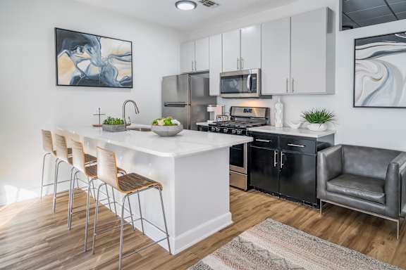 A modern kitchen with a white island and black appliances.at Iris Luxury Apartments, Memphis, 38105