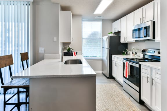 an open kitchen with white cabinets and black appliances and a white counter top at Legacy Farm, Collierville, Tennessee