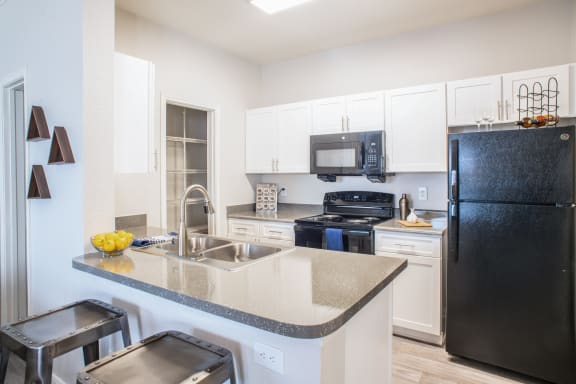 a kitchen with white cabinets and black appliances at Lincoln at Wolfchase, Cordova