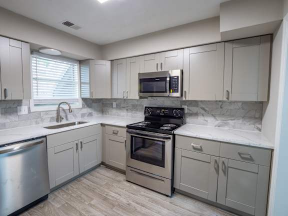 modern kitchen with stove and cabinet at Manchester at Mansell, Roswell Georgia