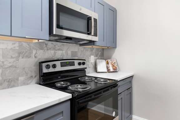 black stove and a microwave in kitchen at Manchester at Mansell, Roswell