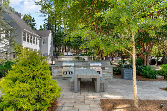 A backyard with a picnic table and a tree. at Manchester at Mansell, Roswell