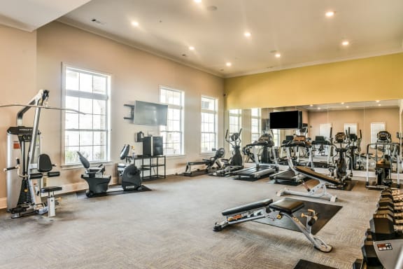 a spacious fitness room with cardio equipment and a flat screen tv at Meridian Park in Collierville, TN 38017