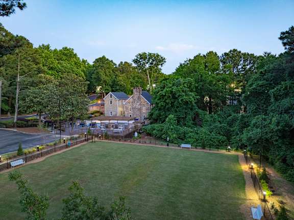 A large house is surrounded by trees and has a grassy yard. at Mill House at East Cobb, Marietta Georgia