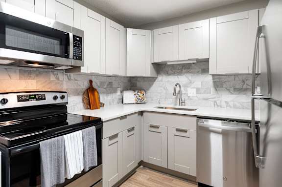 kitchen with white cabinets and black stove at Mill House at East Cobb, Marietta Georgia