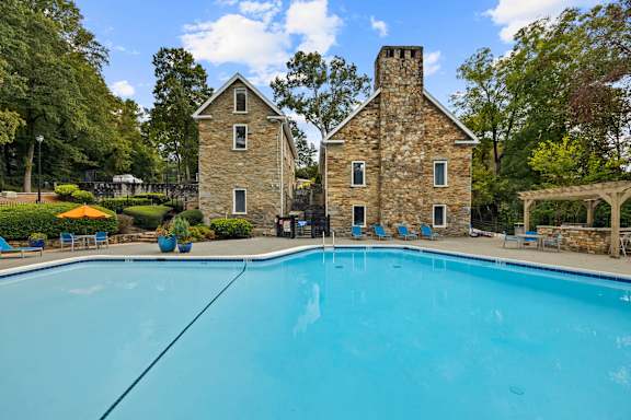 pool with trees and stone buildings at Mill House at East Cobb, Marietta, GA 30067
