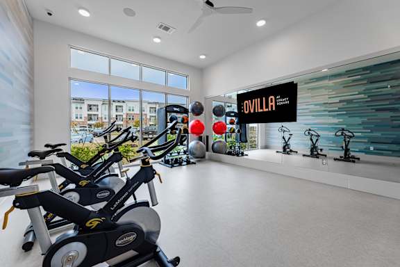 A gym with exercise equipment and a sign that says "Ovilla".