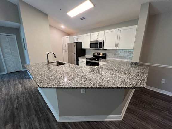 a kitchen with a granite counter top and a sink at Paradise Island, Jacksonville, FL