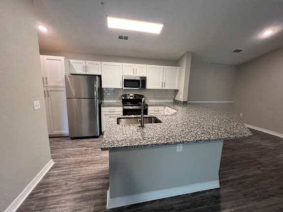 a kitchen with granite counter top and stainless steel appliances at Paradise Island, Jacksonville, Florida