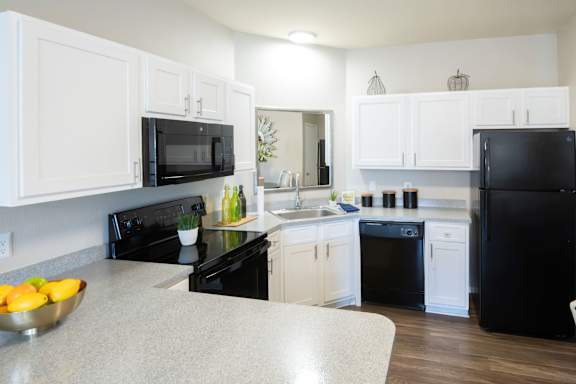 A kitchen with black appliances and white cabinets. at Park at Forest Hill Apartments, Memphis, Tennessee