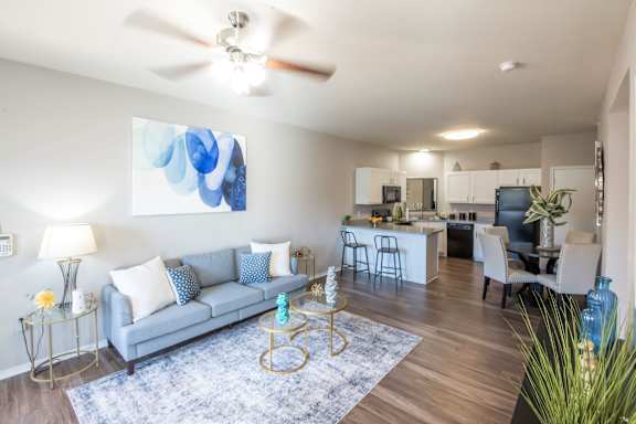 A living room with a grey couch and a blue rug. at Park at Forest Hill Apartments, Memphis
