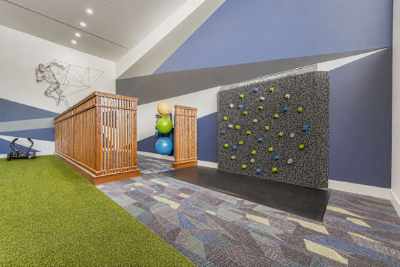 A room with a climbing wall and a wooden podium.