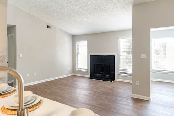 A modern living room with a fireplace and a dining table set for two. at Station Heights, Georgia ,30022