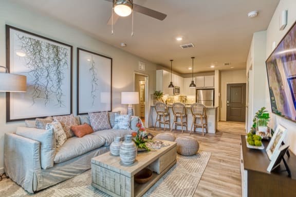 a living room with a couch and a coffee table in front of a kitchen at The Beck at Hidden River, Tampa, FL, Florida