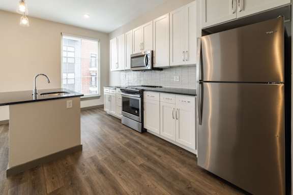 A modern kitchen with a stainless steel refrigerator and wooden floors. at The Tennessee Brewery, Memphis