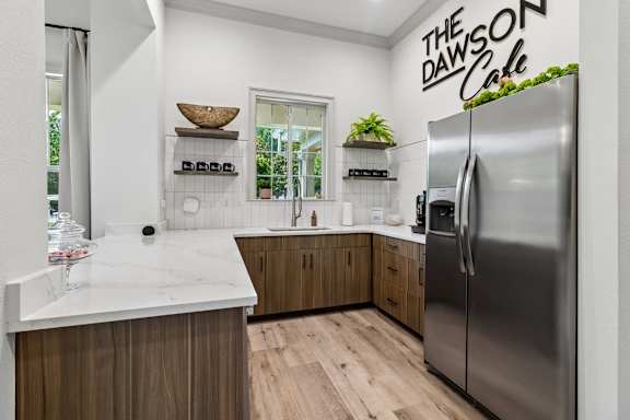 A modern kitchen with a marble countertop and wooden cabinets.