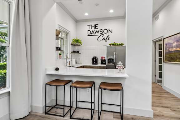 A cafe with a white counter and two stools.